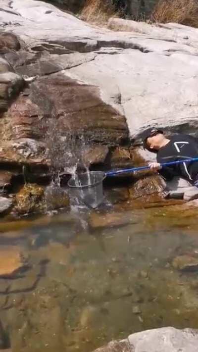 Fishing while relaxing on the rock.