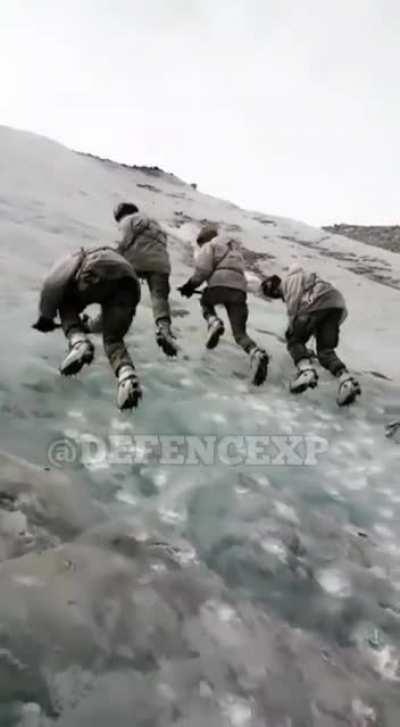 Indian soldiers practicing climbing steep mountains.