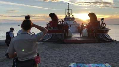 Belligerent drunk at Wreck Beach being carted off by the hovercraft.