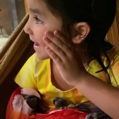 Adorable girl cuddling with her friend Macaw.