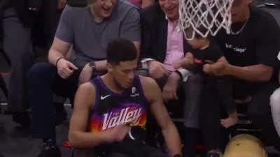 Devin Booker makes the tough shot and shares a fist pump with a baby