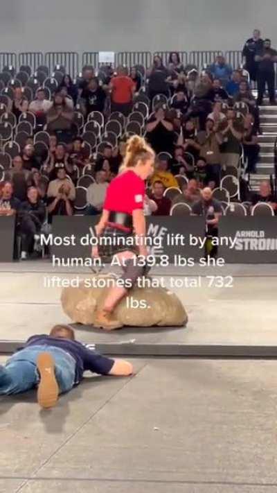 Woman (under 140lb) lifts two rocks with a combined weight of 732lb