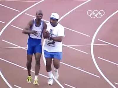 Dad rushes on to track to help son finish races after the son tears his hamstring at the Olympics.