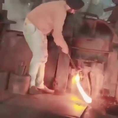 a worker performing manual work at hot Steel mill in india 