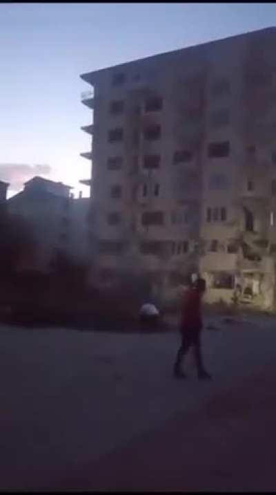 A guy collapsing a building that had been damaged by the recent earthquake in Malatya/Turkey by throwing a stone, yes stone.