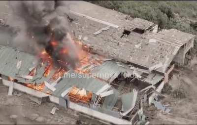 A drone operator spots a Russian Ammunition dump inside a building through a damaged ceiling. Ukrainian artillery destroys the depot.