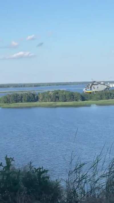 British-supplied Sea King helicopter flies along a river somewhere in Ukraine