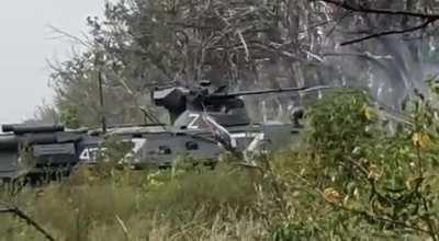 Two Russian BTR-82 fighting in a forest belt under artillery fire