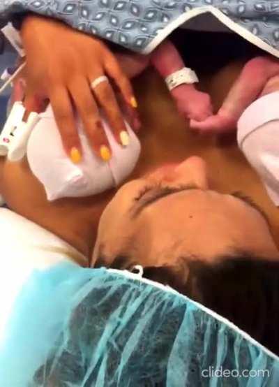 Two sisters hold hands right after birth