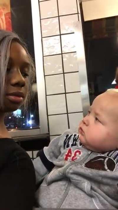 baby stares at woman then smirks