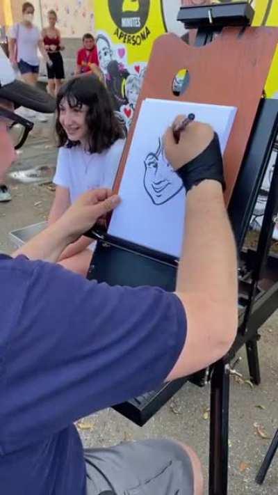 A street artist draws cartoon version of a girl