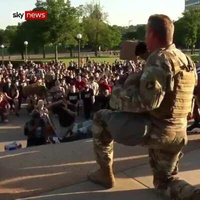 A National Guard officer hugged protesters after taking a knee with them.