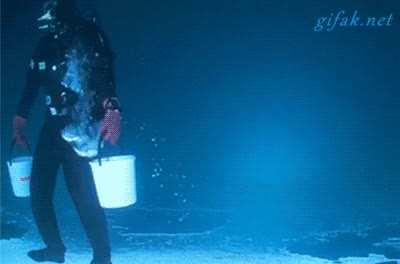 Diver walking upside down under the ice.