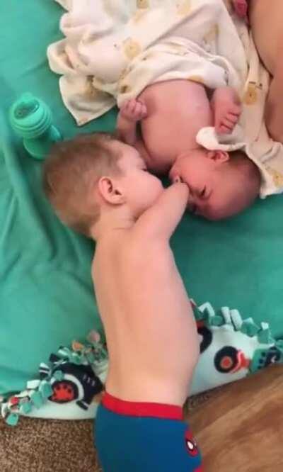 Little kid gives baby brother pacifier