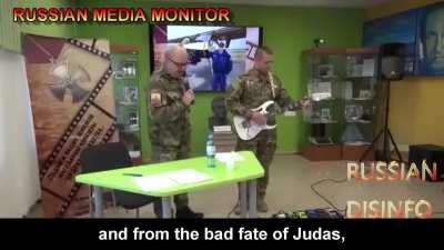 Russian boomer sings a propaganda song about Putin's fascist invasion of Ukraine. The kids don't look thrilled.