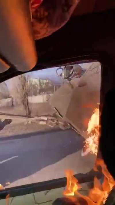 Civilians conduct a messy molotov cocktail driveby on a Russian vehicle being towed by a tractor.