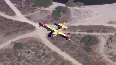 Amphibious firefighting aircraft skimming to refill its water tanks