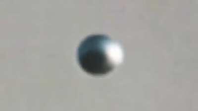 Metallic spherical UFO dissappears caught on filn over Poland. 6/30/ 2017