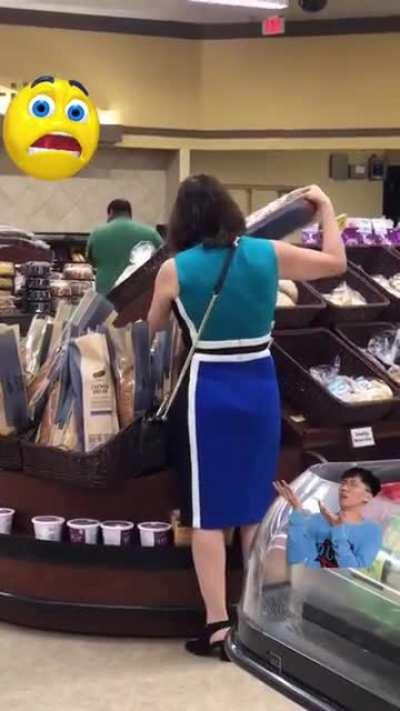 Woman touches all of the French bread in a grocery store