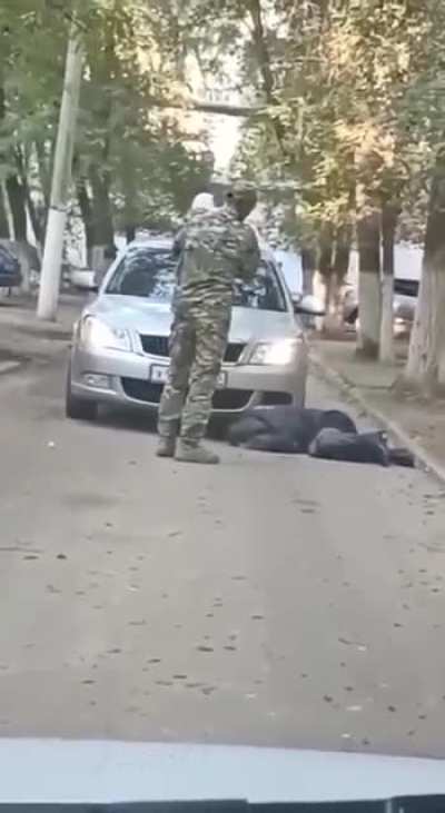 Russian soldier with an Akhmat patch kicks and brutalises a woman in Astrakhan, presumably the mother of his child, while holding said child, with bystanders filming and not intervening.