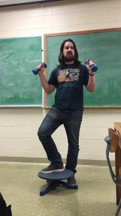 High school teacher wows his students with a real life demonstration for Conservation of angular momentum