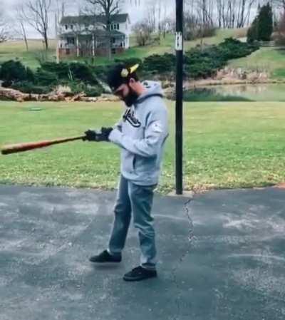 Guy fooling around in driveway during social isolation trying to remember his moves from high school baseball