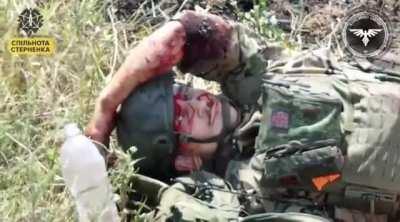 A Ukrainian FPV drone hits a Russian soldier, whose comrades put a tourniquet on his leg, then quickly abandon him. He lies bleeding, covered in flies, as he stares at the Ukrainian observation drone that's watching him.