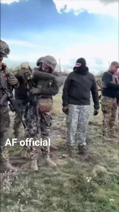 Lineup of Ukrainian soldiers with flags flying and a British-supplied Spartan APC.