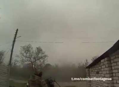 A Chechen from Kadyrov's battalion fires two machine guns at once towards Ukrainian positions.