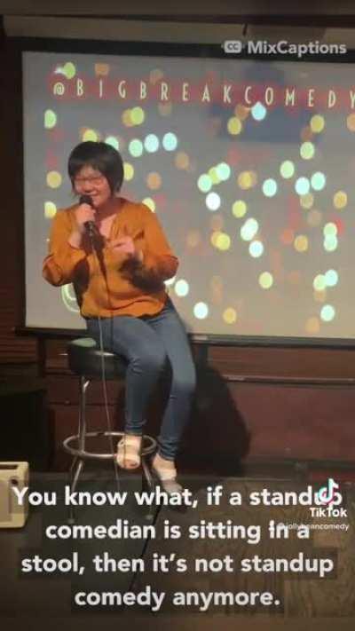 Standup comedian sitting on a stool