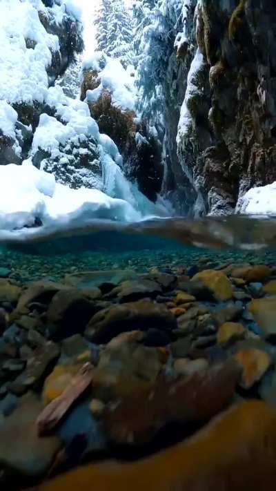 Snow falling on crystal clear Alaskan glacial melt water. Credit: Photographer John Derting.