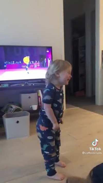 Little girl watches Olympics women’s weightlifting