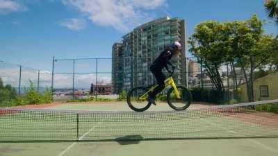 Danny MacAskill cycling across a tennis net