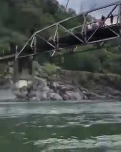 Woman rope jumps from a bridge and does a spectacular flip and dive