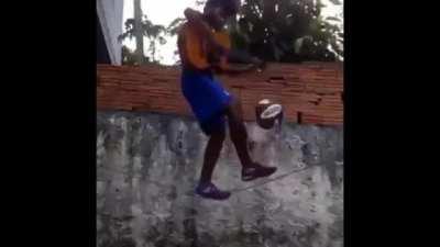 Playing a guitar and balancing a football while on a thin wire