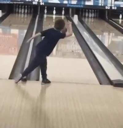 Little kid showing off his bowling skills