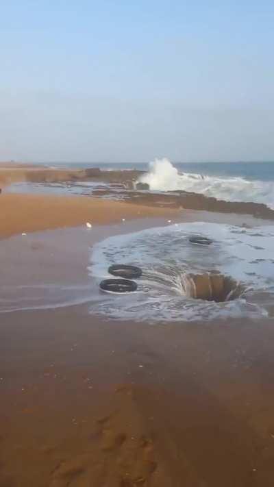 The outpouring of huge pressure from the waves from the sea underneath the rock..