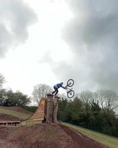 Professional Mountain Bike Rider Matt Jones lands a back flip to front flip off a hitching post