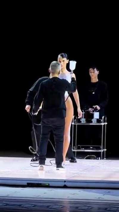 Naked Bella Hadid has a dress spray-painted onto her body in the middle of a fashion show