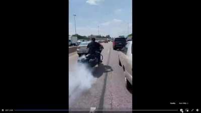 Motorcyclist swerving near cars in traffic.