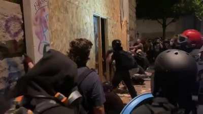 Rioters in portland tearing down the boards over the windows at the federal courthouse, then smashing windows