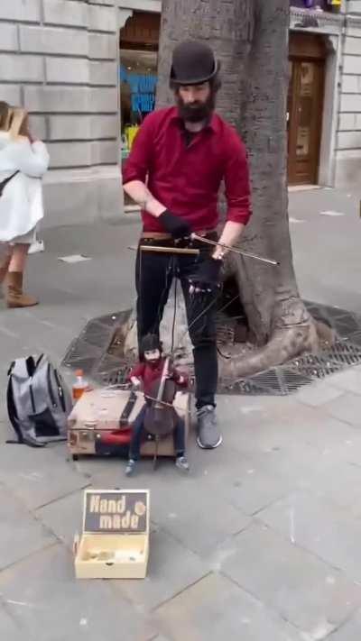 This puppet master makes it look like the puppet is playing a cello on the streets of Italy