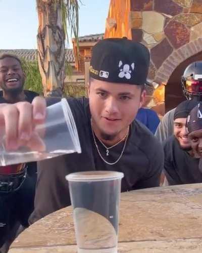 Bunch of guys try to pour water into a cup, the person to make it overflow gets dunked into a pool