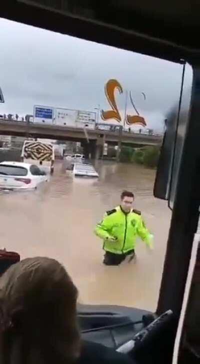 Aracında kalıp, yardıma ihtiyacı olan var mı diye kontrol eden polis