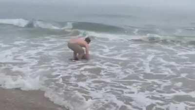 🔥 Guy rescuing a young Heaviside’s dolphin that got stranded on the beach 🔥