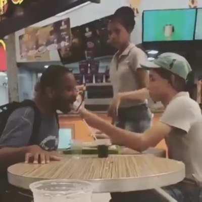 Restaurant worker volunteers to help a handicapped person while he eats. Going above and beyond duty.