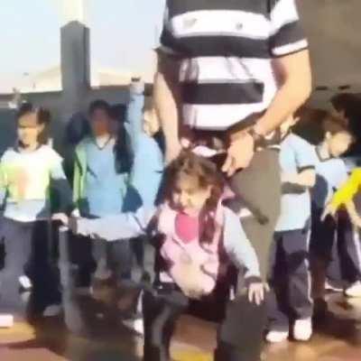 PE teacher helps a disabled girl dance with her classmates