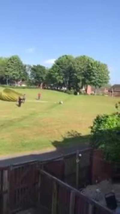 Opening a parachute in a windy field.