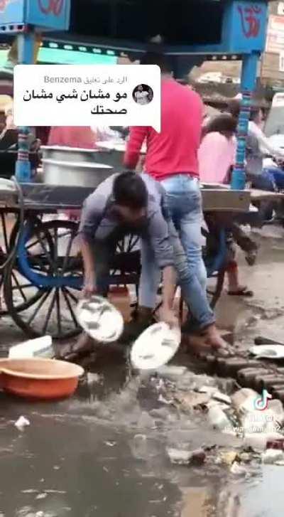 Street food vendors in India cleaning the trays