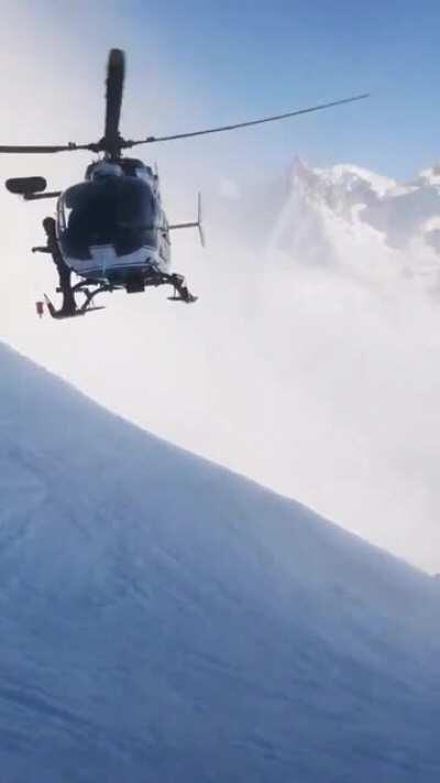 A French police helicopter traveled 7,000 feet up a windy mountainside, getting inches from the snowy slope, in an effort to rescue an injured skier. Unbelievable flying and skill by the pilot.